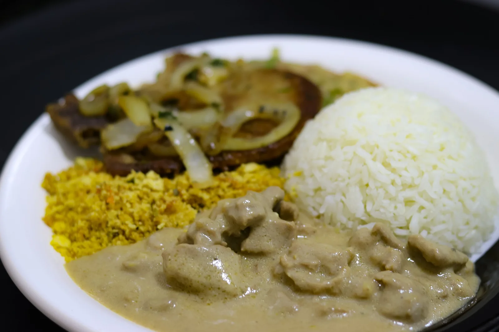 Prato feito com bife acebolado, arroz, farofa e estrogonofe